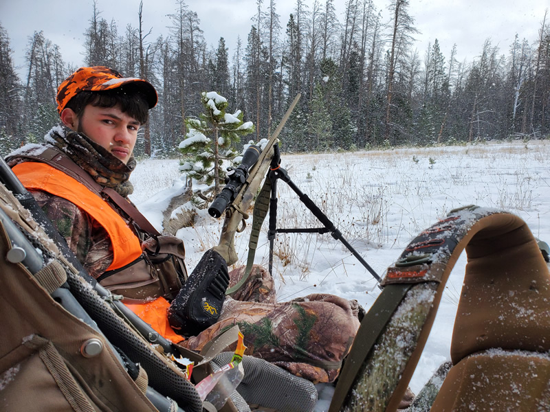 Sitting on the edge of a meadow with X-Bolt rifle in the Uinta mountains.