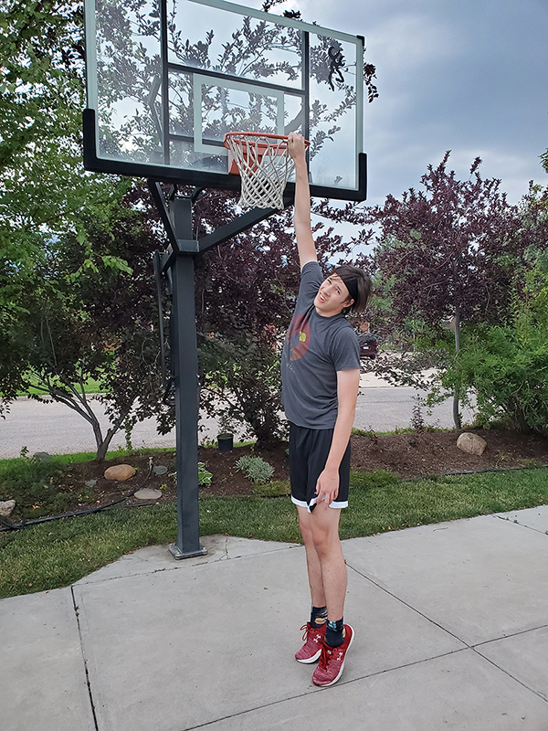 7 foot tall Landen Smith grabbing rim with feet on the ground