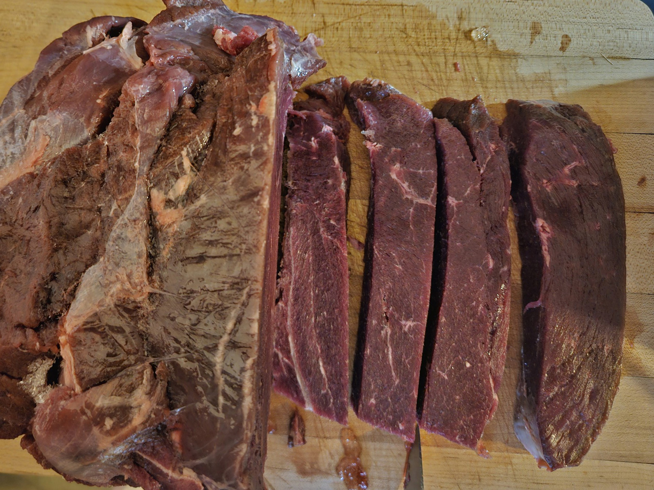 Slicing partially frozen meat ready to be ground